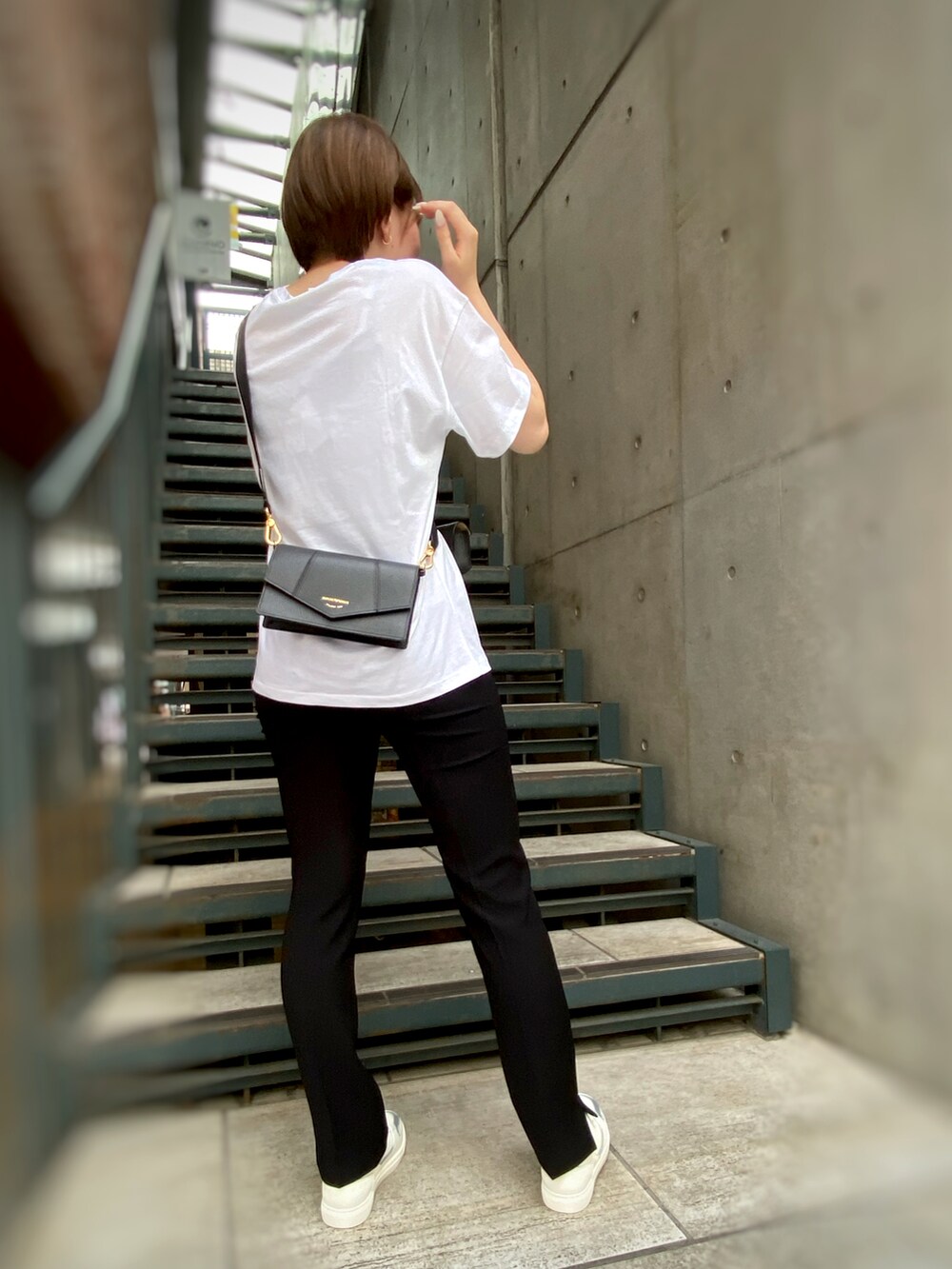 ブラック系のパンツ、ホワイト系のTシャツ/カットソー、ブラック系のショルダーバッグを着用したレディースの秋コーディネートの2枚目の写真