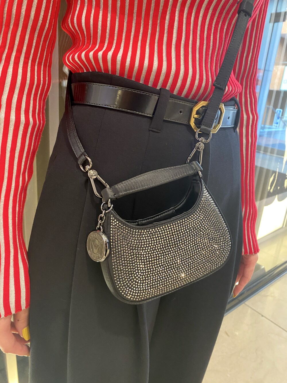 ブラック系のパンプス、レッド系のニット/セーター、ブラック系のパンツを着用したレディースの秋コーディネートの2枚目の写真