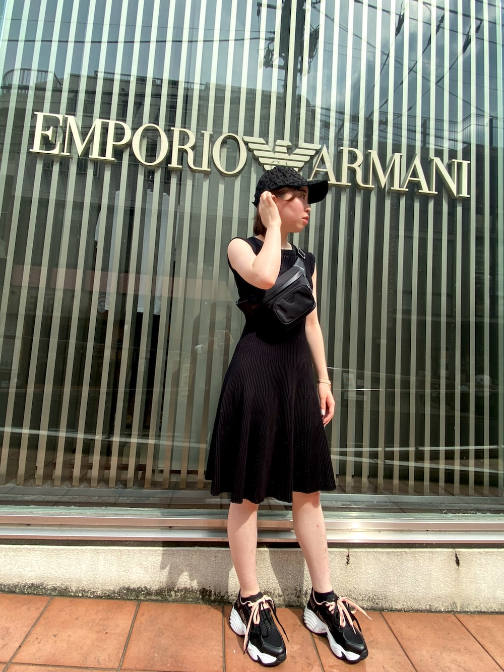 ブラック系のワンピース、ブラック系のボディバッグ/ウエストポーチ、ブラック系のスニーカーを着用したレディースの夏コーディネートの2枚目の写真