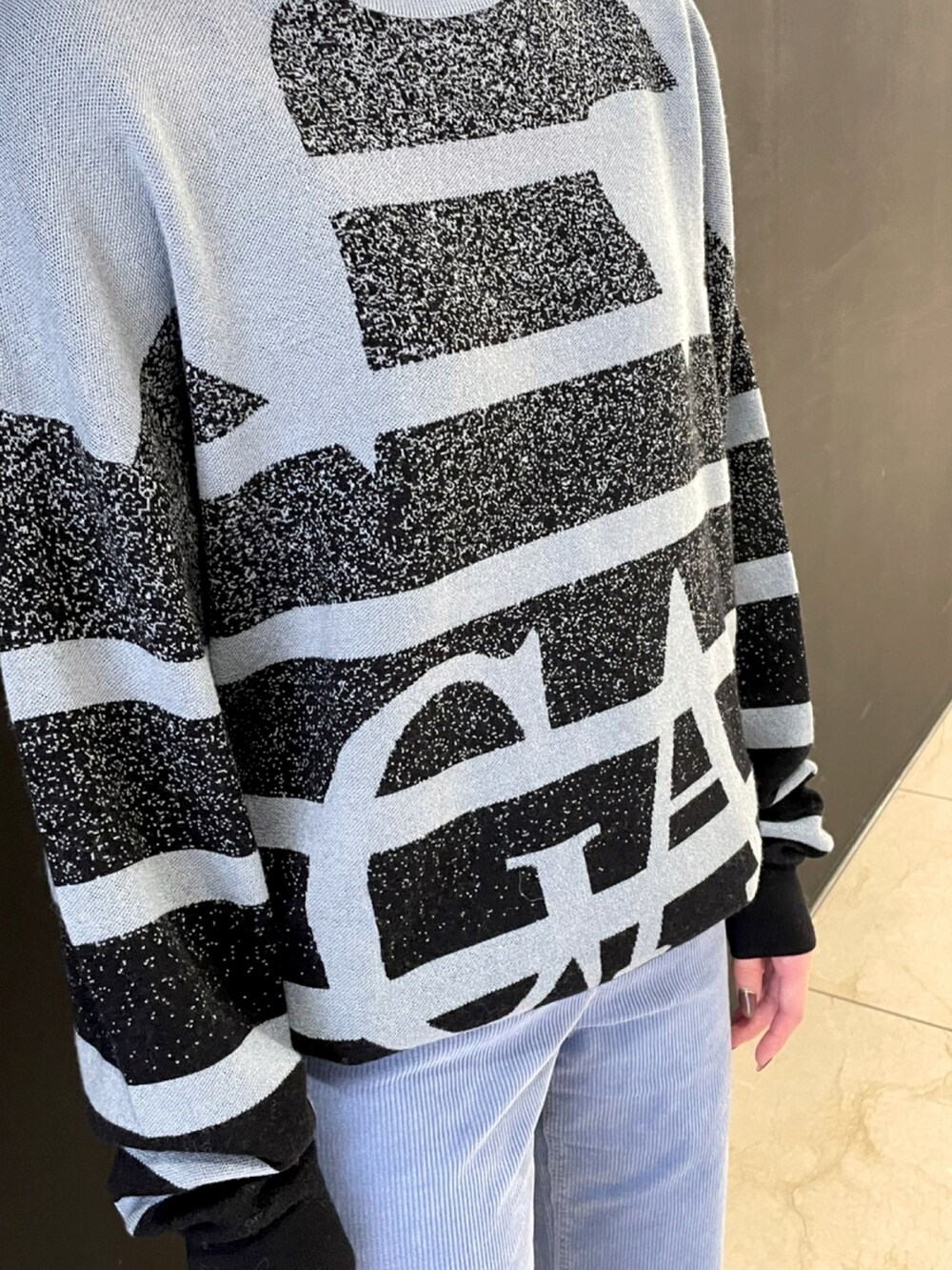 ブルー系のニット/セーター、グレー系のジャケット/アウター、ブルー系のパンツを着用したレディースの秋コーディネートの3枚目の写真