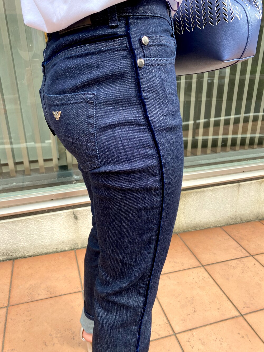 ホワイト系のTシャツ/カットソー、ブルー系のデニムパンツ、ブルー系のショルダーバッグを着用したレディースの秋コーディネートの2枚目の写真