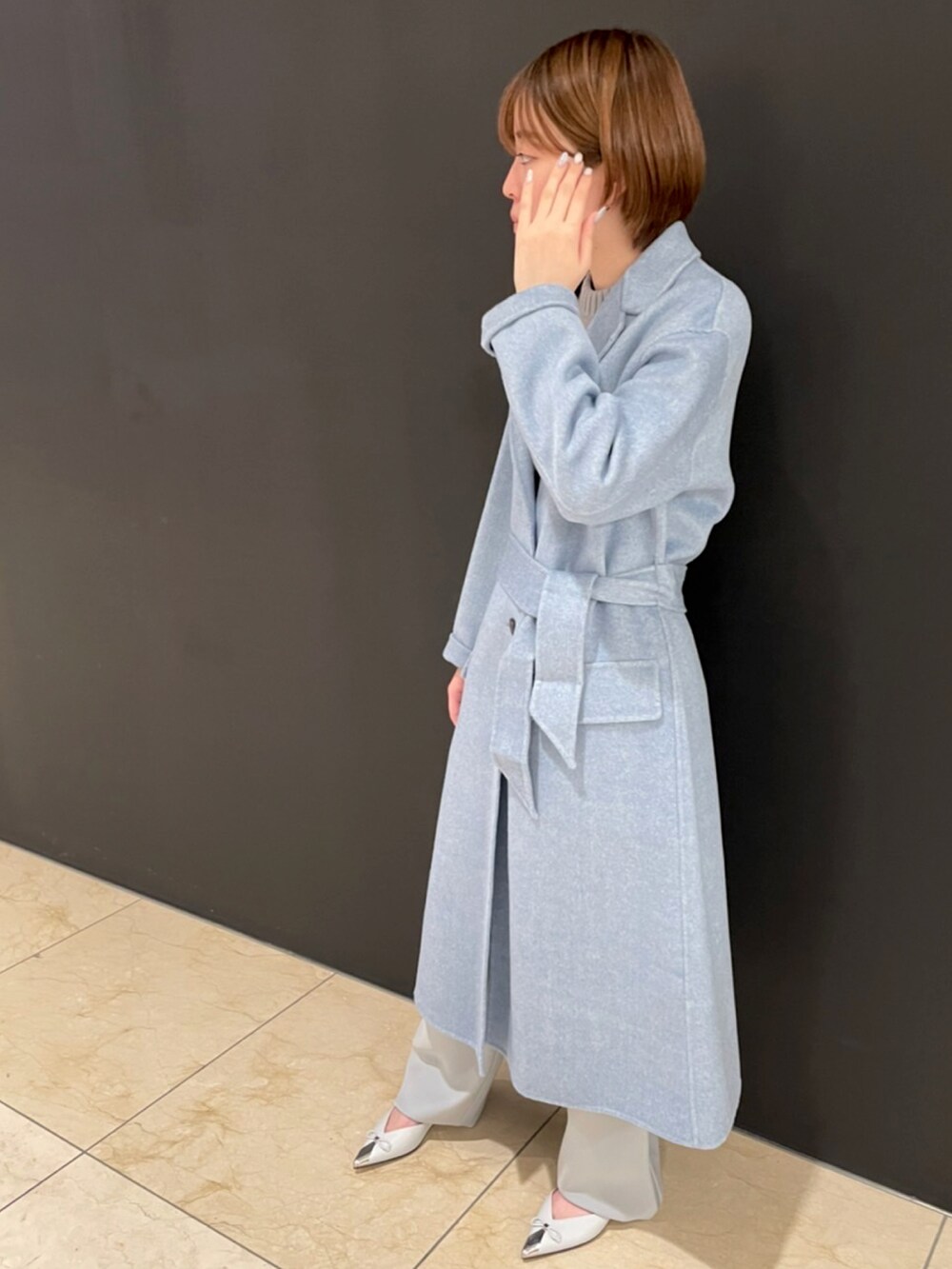 ブルー系のジャケット/アウター、ベージュ系のニット/セーター、グレー系のパンツを着用したレディースの秋コーディネートの3枚目の写真