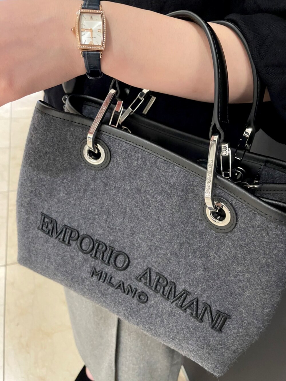 グレー系のショルダーバッグ、ブラック系のトップス、グレー系のスカートを着用したレディースの秋コーディネートの4枚目の写真