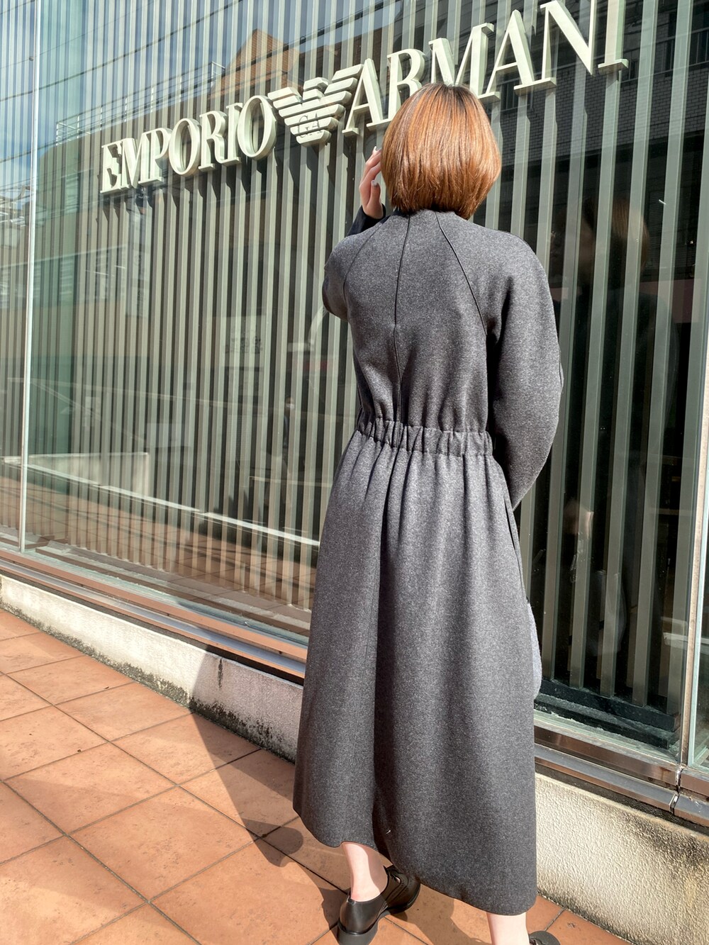 グレー系のワンピース、ベージュ系のカーディガン/ボレロ、グレー系のショルダーバッグを着用したレディースの秋コーディネートの3枚目の写真