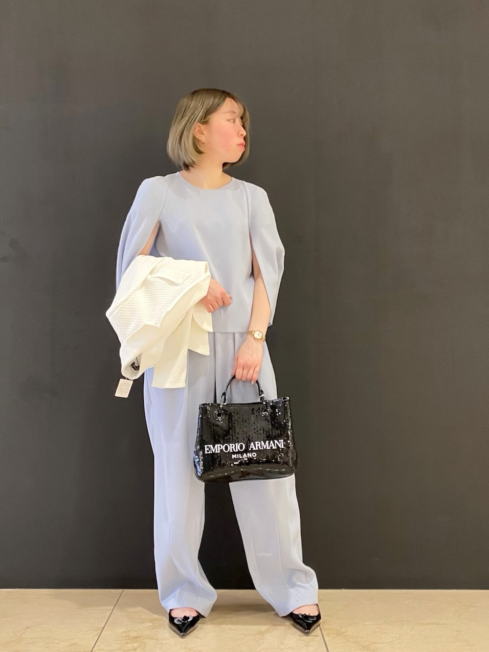 ホワイト系のジャケット/アウター、ブラック系のシューズ、ブラック系のハンドバッグを着用したレディースの冬コーディネートの2枚目の写真