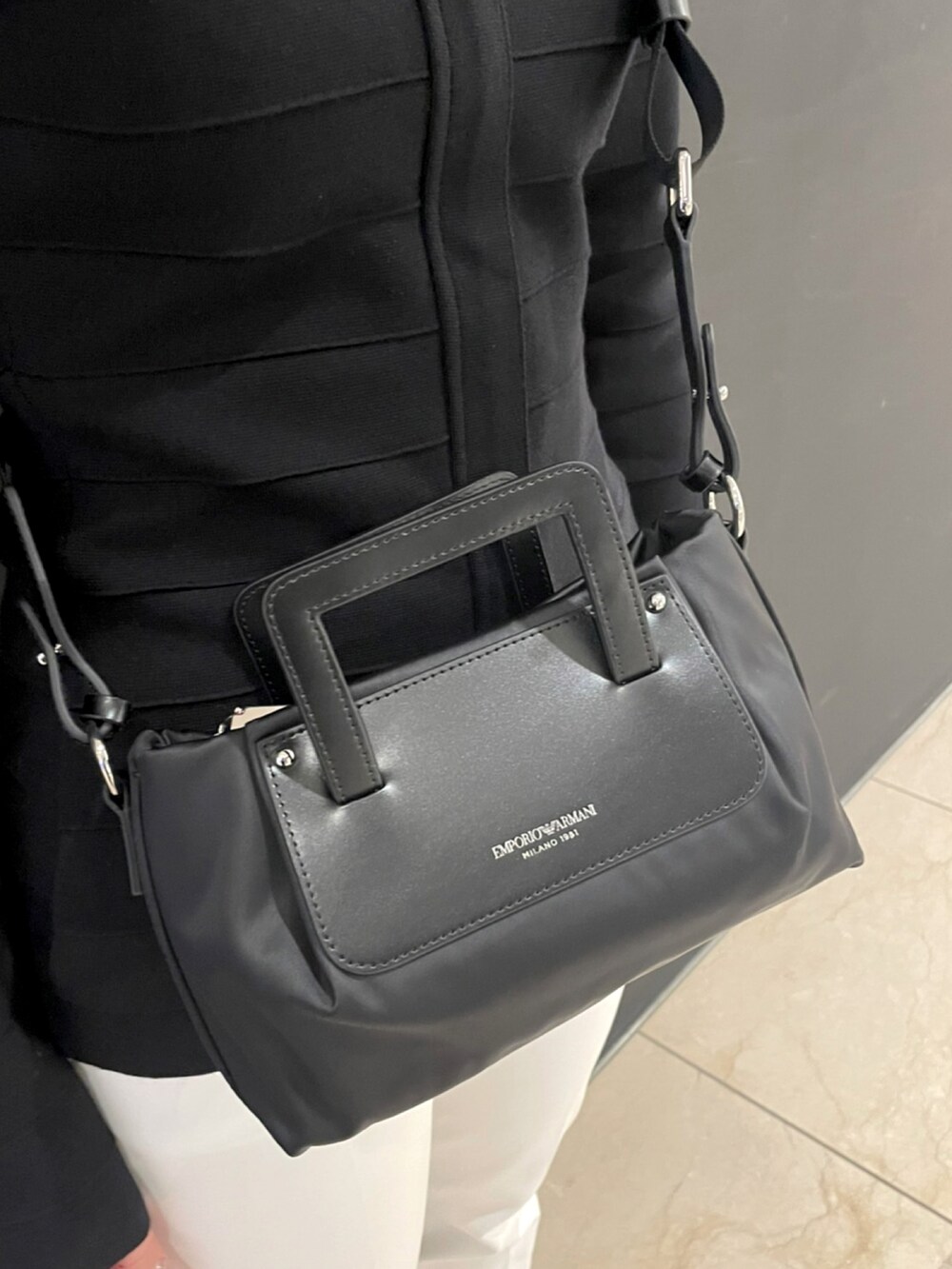 ブラック系のジャケット/アウター、ブラック系のバッグ、ホワイト系のパンツを着用したレディースの春コーディネートの3枚目の写真