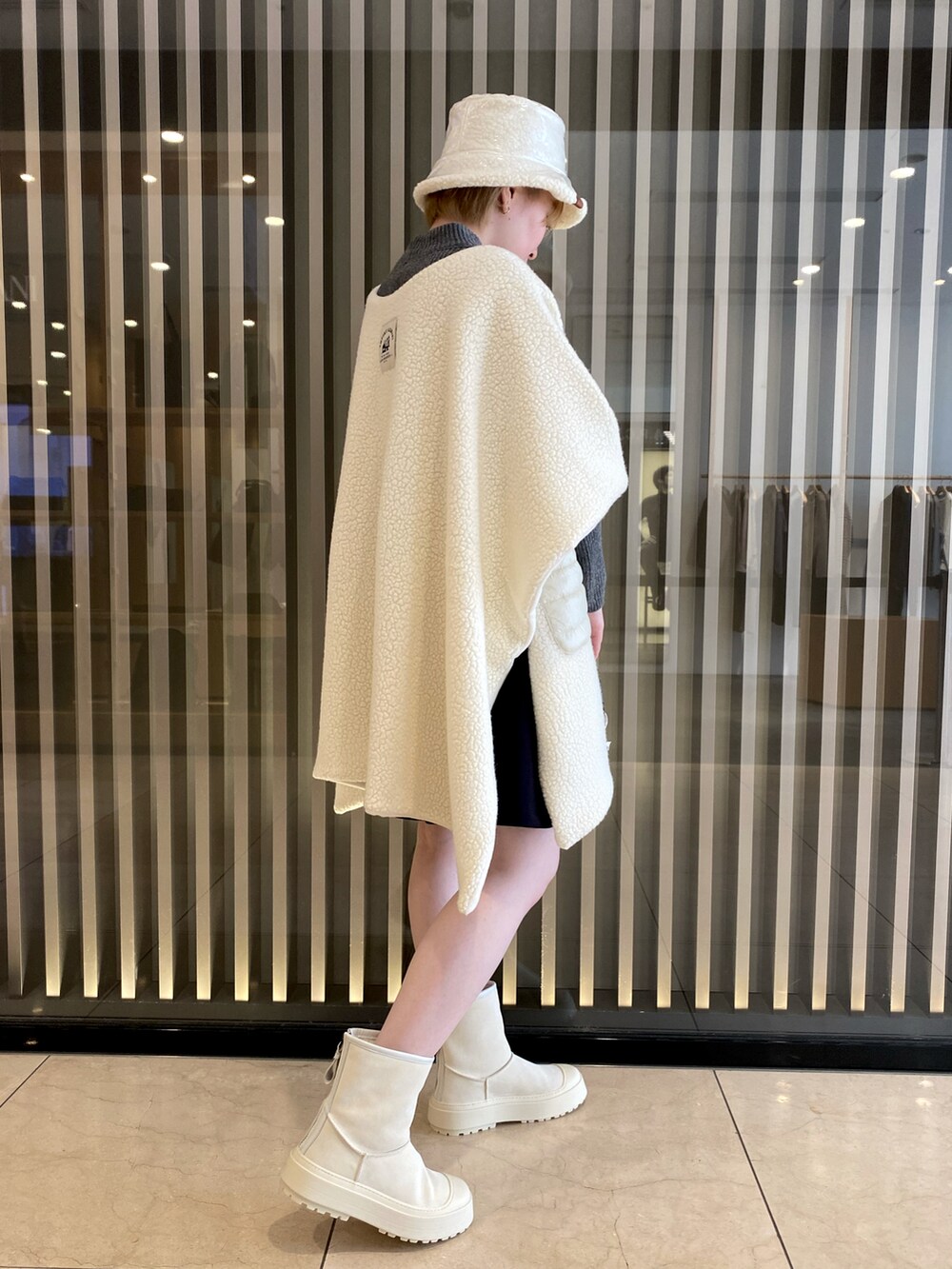 グレー系のニット/セーター、ホワイト系のハンドバッグ、ブラック系のスカートを着用したレディースの秋コーディネートの2枚目の写真