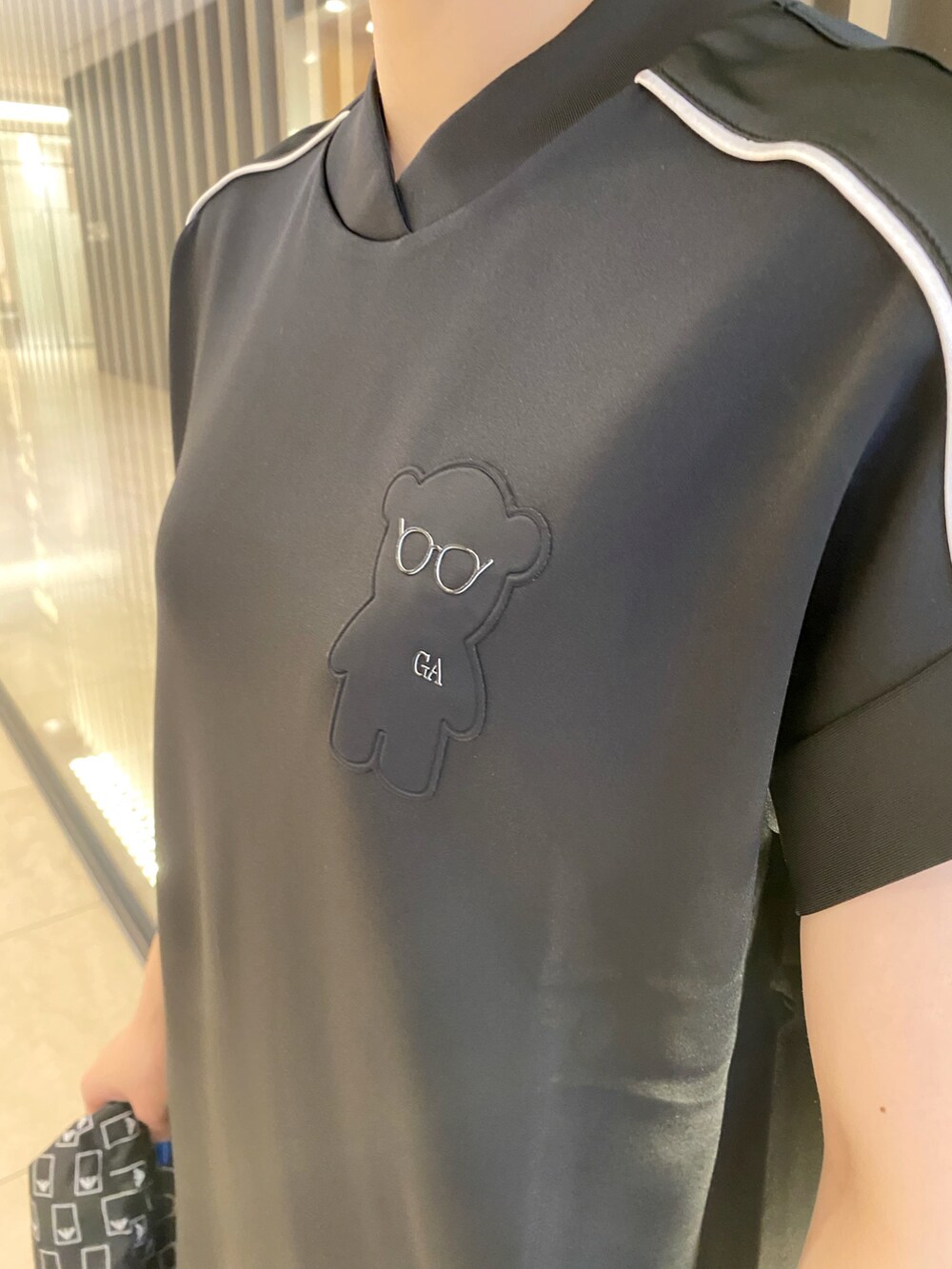 ブラック系のブルゾン、ホワイト系のスニーカー、ブラック系のワンピースを着用したレディースの秋コーディネートの3枚目の写真