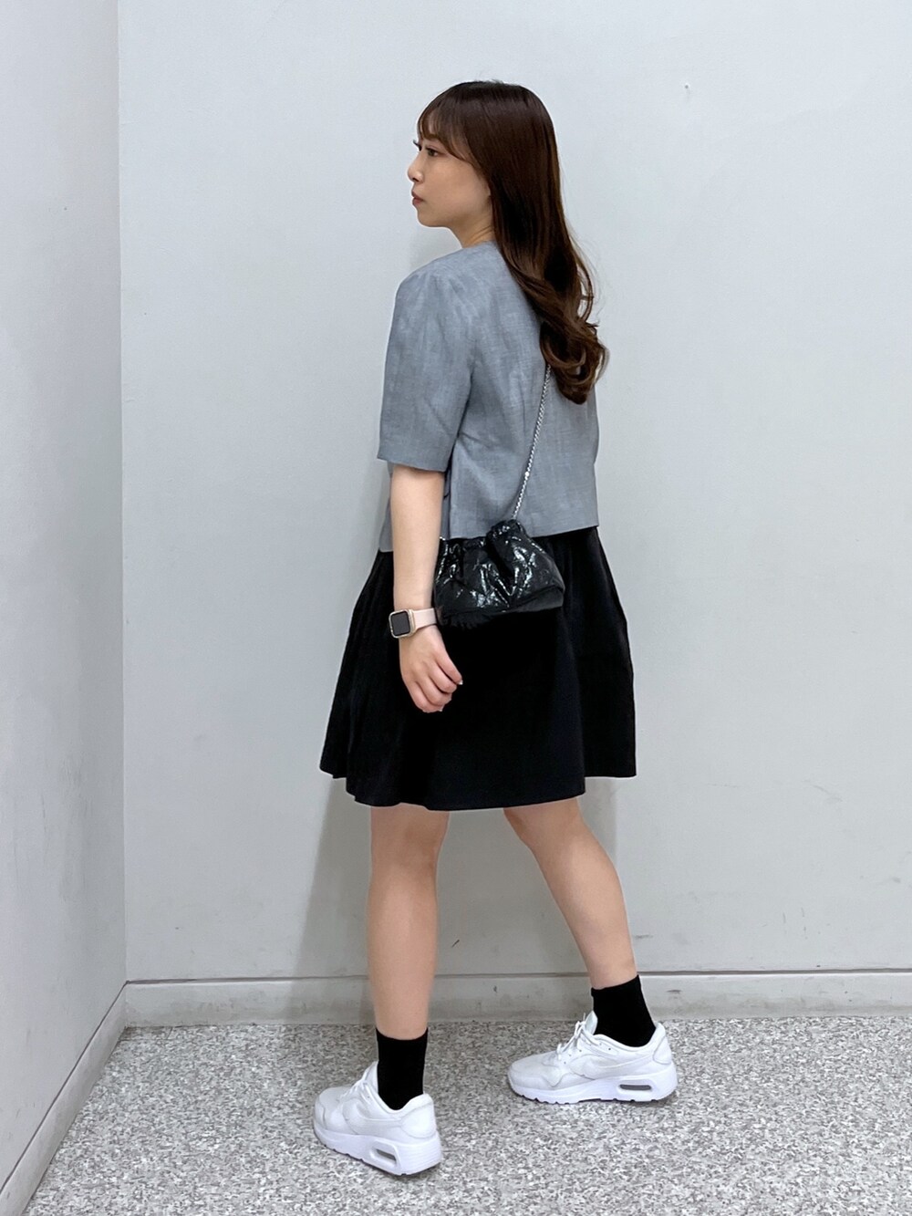 グレー系のノーカラージャケット、ブラック系のワンピース、ブラック系のショルダーバッグを着用したレディースの春コーディネートの2枚目の写真