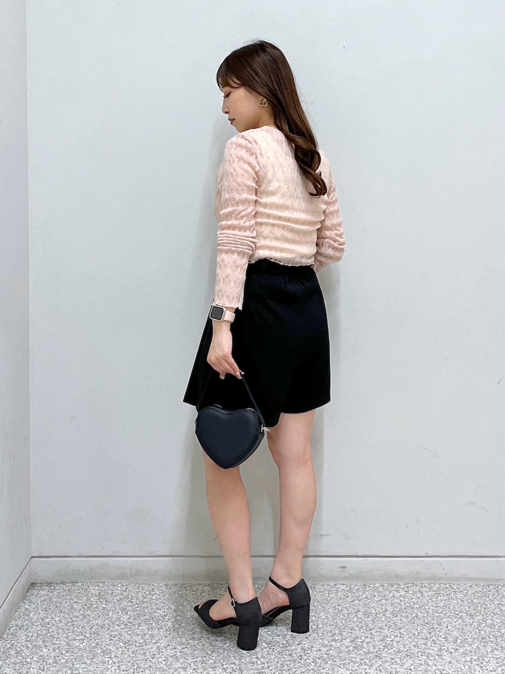 ブラック系のショルダーバッグ、ブラック系のサンダル、ピンク系のカーディガン/ボレロを着用したレディースの春コーディネートの2枚目の写真