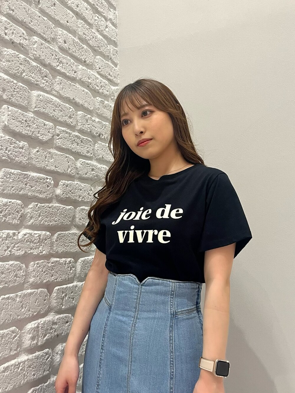 ブルー系のデニムスカート、ホワイト系のカーディガン/ボレロ、ブラック系のTシャツ/カットソーを着用したレディースの春コーディネートの3枚目の写真