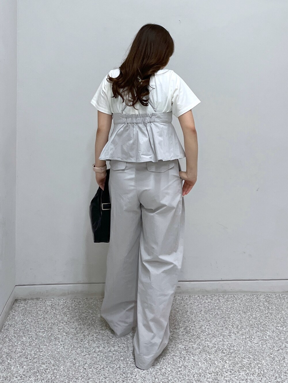 ホワイト系のサンダル、ブラック系のショルダーバッグ、グレー系のベストを着用したレディースの春コーディネートの3枚目の写真