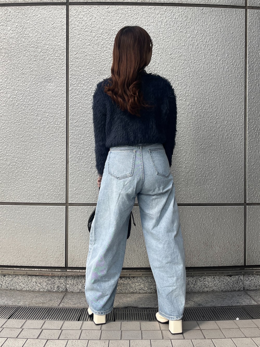 ブルー系のカーディガン/ボレロ、ブルー系のデニムパンツ、ブラック系のショルダーバッグを着用したレディースの冬コーディネートの3枚目の写真