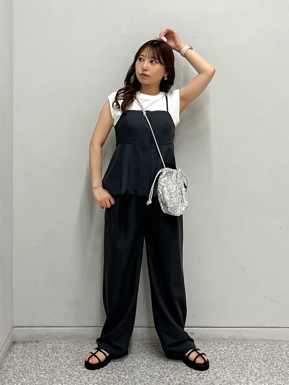 シルバー系のハンドバッグ、ホワイト系のTシャツ/カットソー、ブラック系のシャツ/ブラウスを着用したレディースの春コーディネートの2枚目の写真