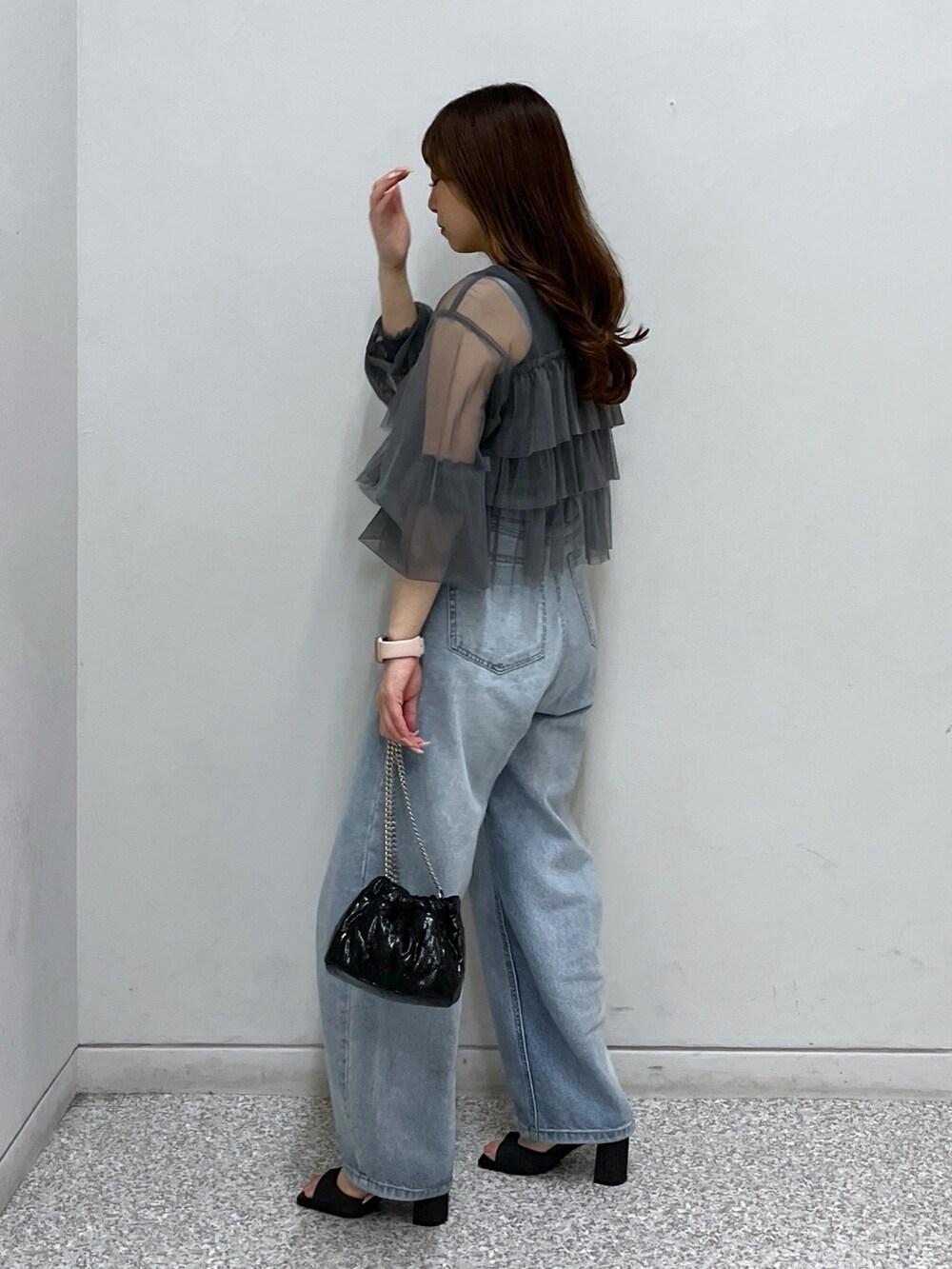 ブルー系のデニムパンツ、グレー系のシャツ/ブラウス、ブラック系のショルダーバッグを着用したレディースの春コーディネートの2枚目の写真