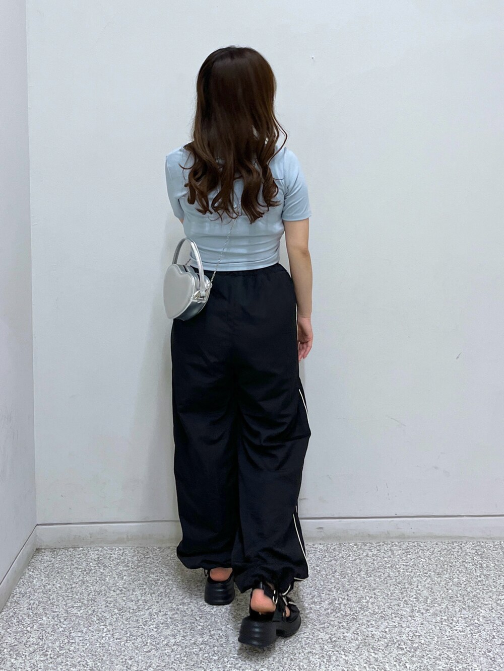 シルバー系のショルダーバッグ、ブルー系のTシャツ/カットソー、ブラック系のその他パンツを着用したレディースの春コーディネートの3枚目の写真