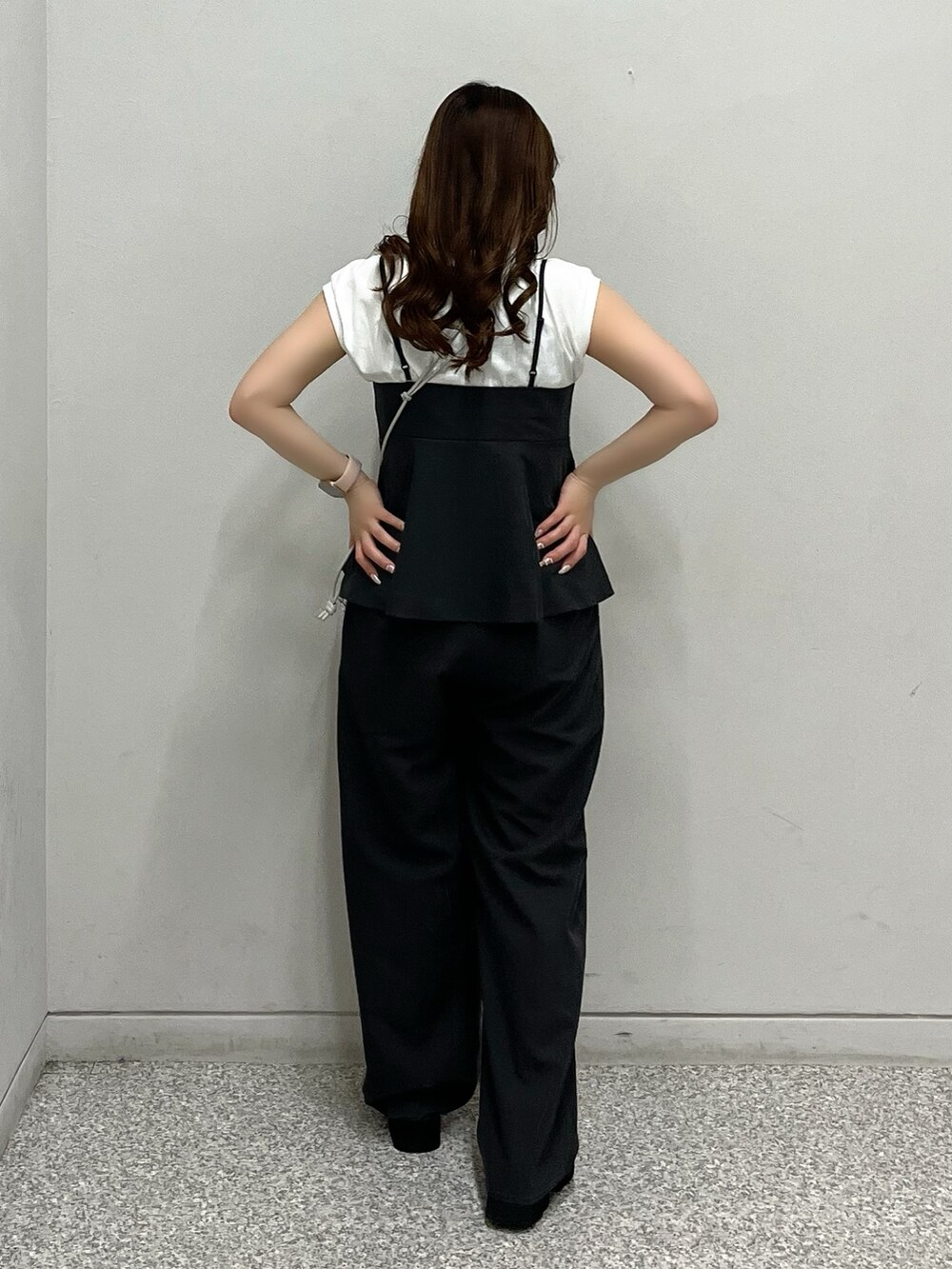 シルバー系のハンドバッグ、ホワイト系のTシャツ/カットソー、ブラック系のシャツ/ブラウスを着用したレディースの春コーディネートの3枚目の写真