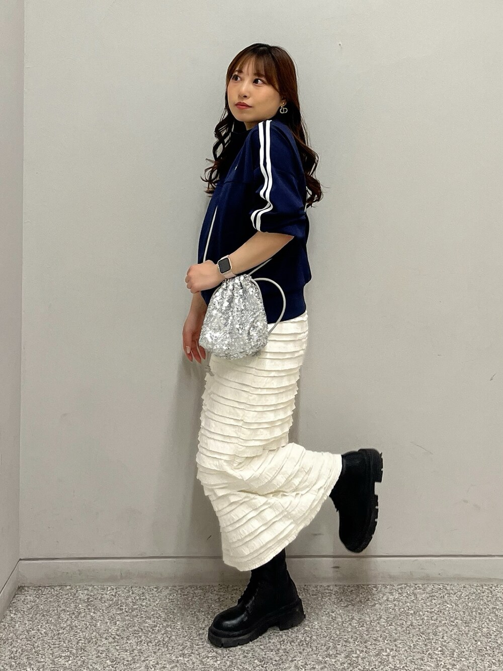 ブルー系のブルゾン、ホワイト系のスカート、シルバー系のハンドバッグを着用したレディースの春コーディネートの2枚目の写真