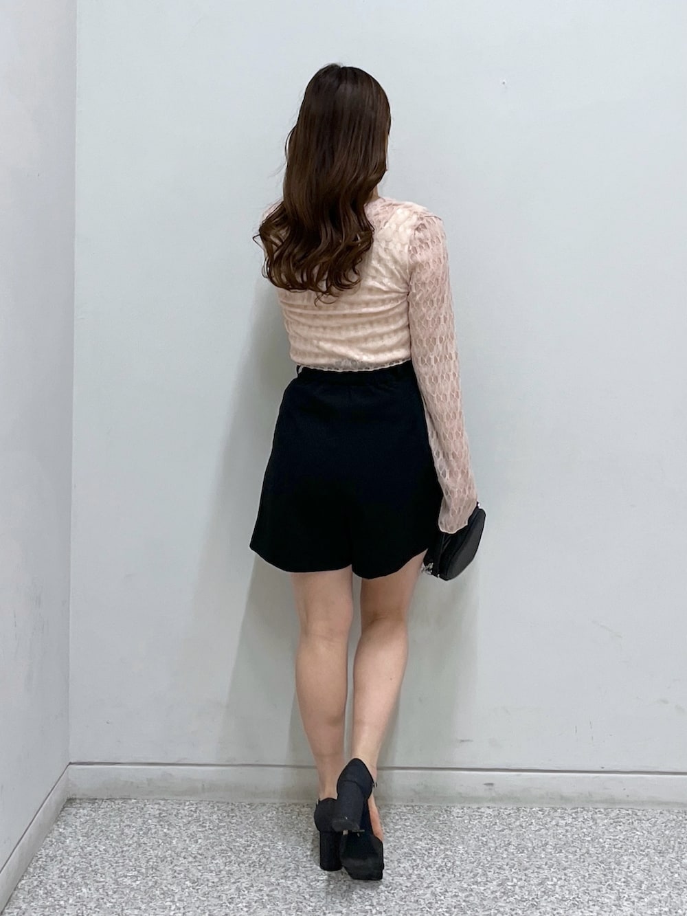 ブラック系のショルダーバッグ、ブラック系のサンダル、ピンク系のカーディガン/ボレロを着用したレディースの春コーディネートの3枚目の写真