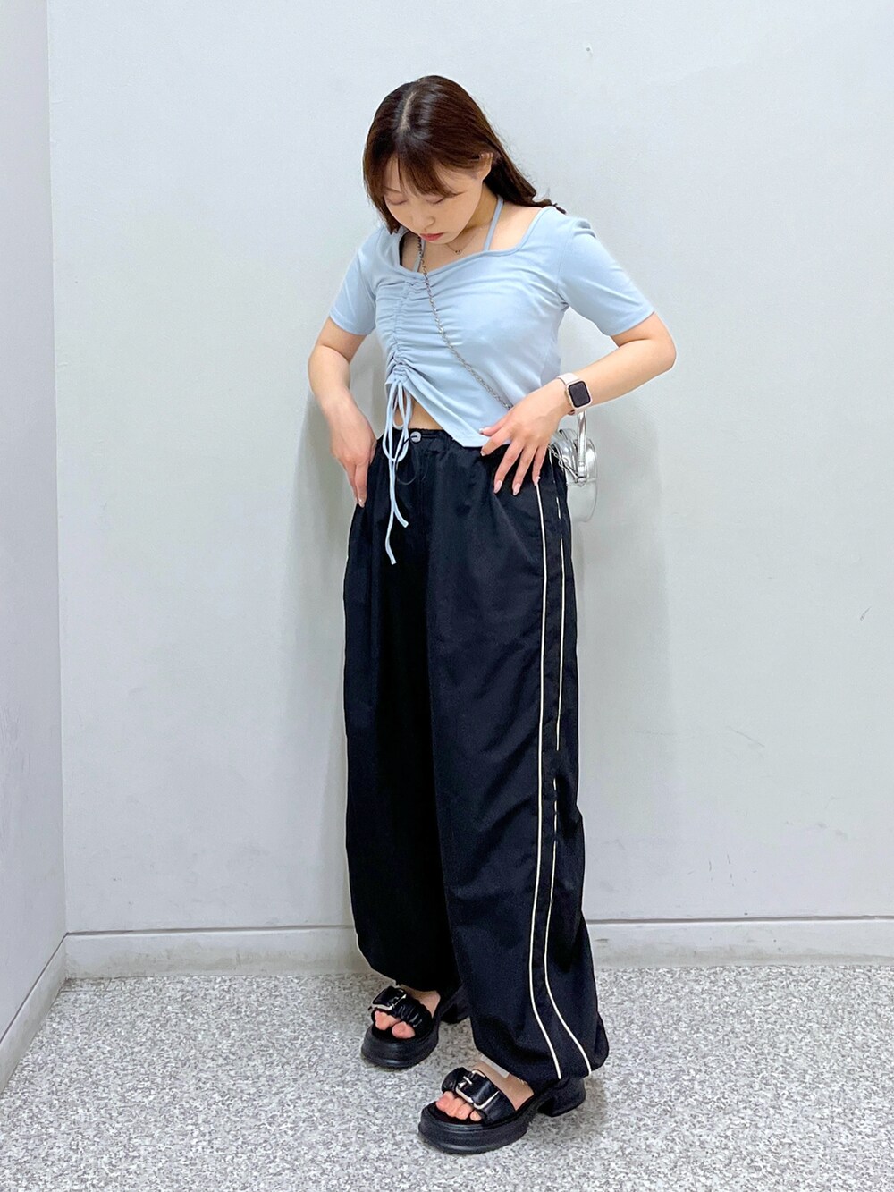 シルバー系のショルダーバッグ、ブルー系のTシャツ/カットソー、ブラック系のその他パンツを着用したレディースの春コーディネートの2枚目の写真