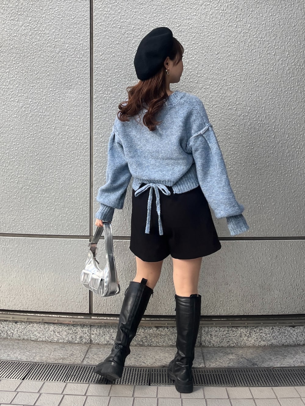 ブルー系のニット/セーター、ブラック系のその他パンツ、シルバー系のショルダーバッグを着用したレディースの冬コーディネートの2枚目の写真