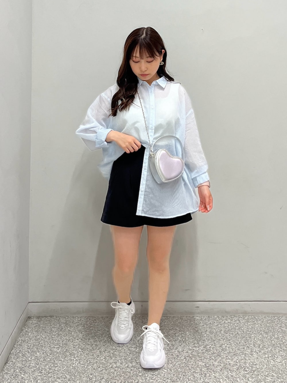 ブラック系のその他パンツ、ブルー系のシャツ/ブラウス、シルバー系のショルダーバッグを着用したレディースの春コーディネートの2枚目の写真