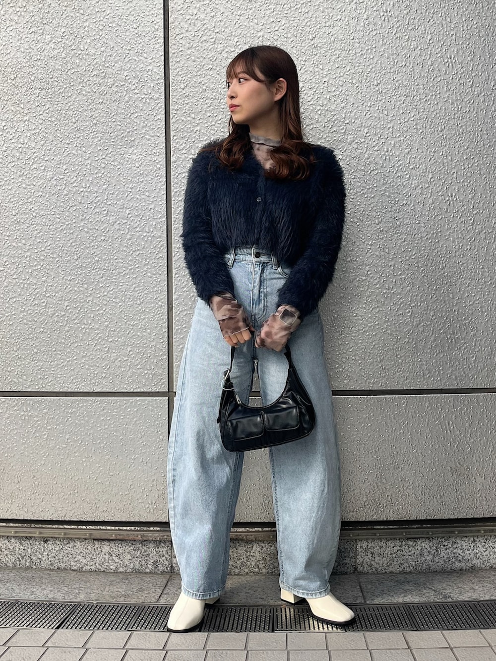 ブルー系のカーディガン/ボレロ、ブルー系のデニムパンツ、ブラック系のショルダーバッグを着用したレディースの冬コーディネートの2枚目の写真