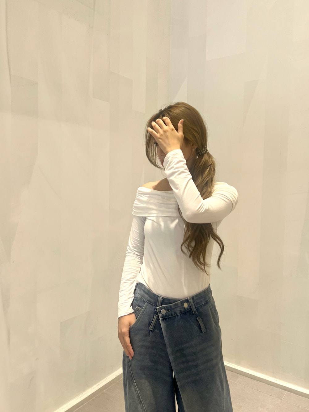 ブルー系のデニムパンツ、ホワイト系のトップス、シルバー系のパンプスを着用したレディースの夏コーディネートの2枚目の写真