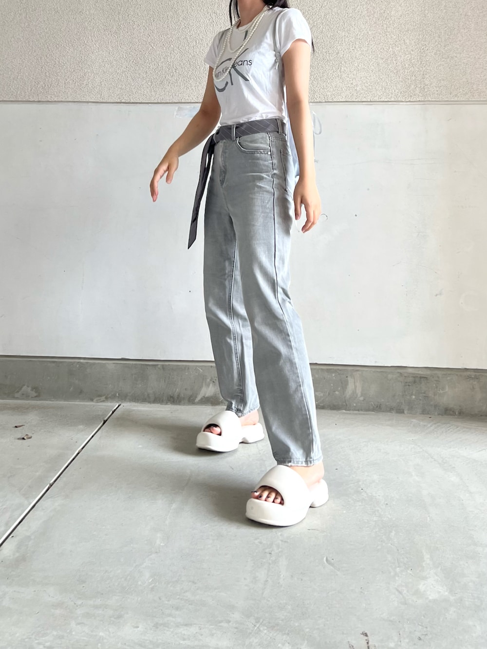 グレー系のパンツ、ホワイト系のTシャツ/カットソー、グレー系のネクタイを着用したレディースの秋コーディネートの4枚目の写真