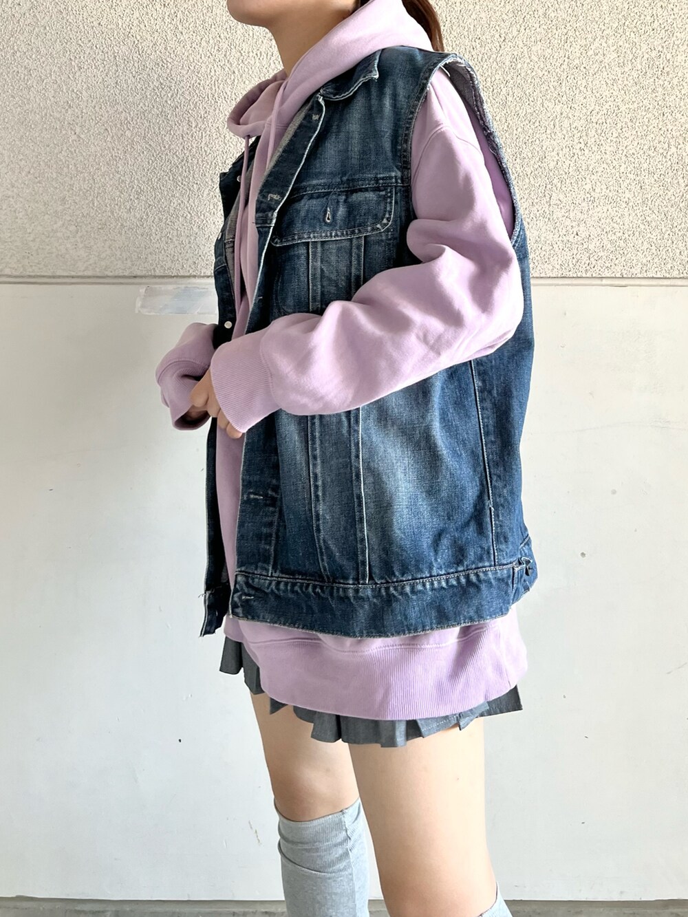 グレー系のスニーカー、ブルー系のデニムジャケット、パープル系のパーカーを着用したレディースの春コーディネートの2枚目の写真