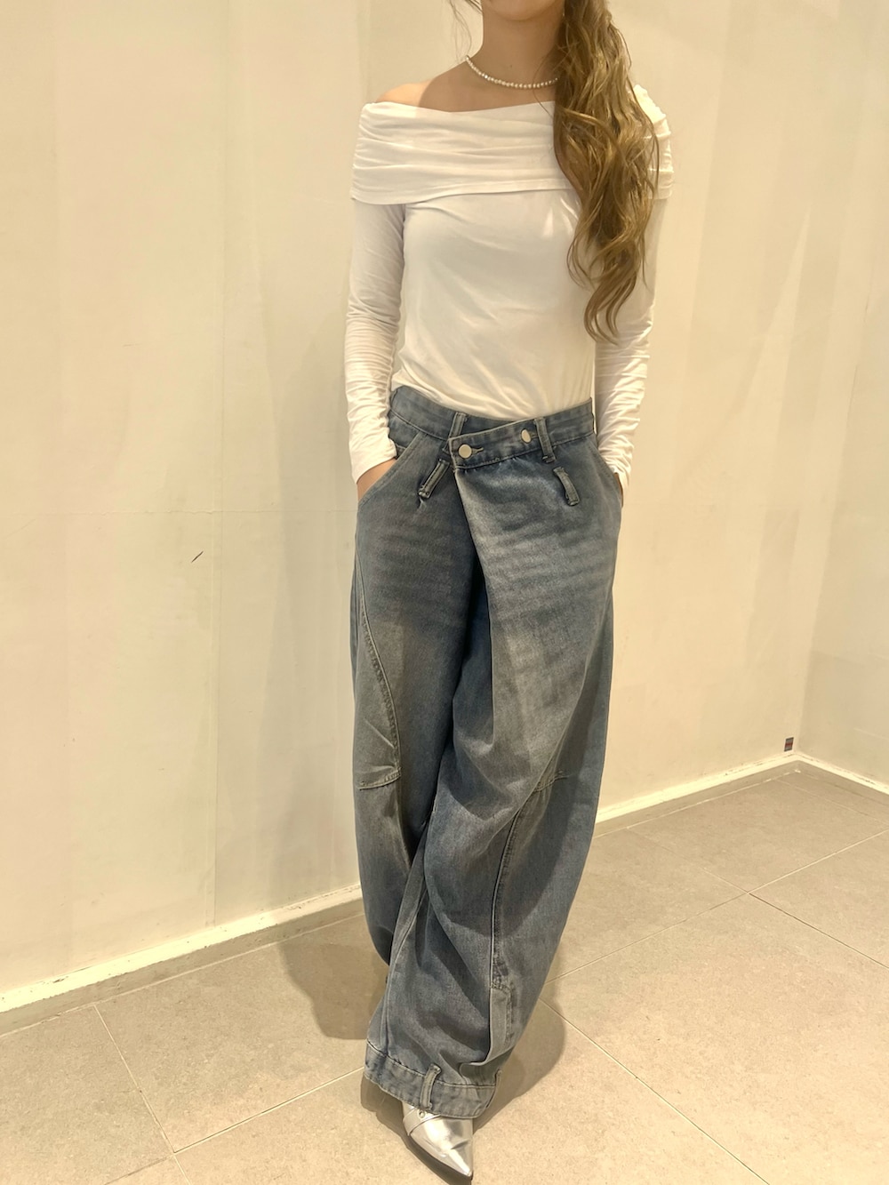 ブルー系のデニムパンツ、ホワイト系のトップス、シルバー系のパンプスを着用したレディースの夏コーディネートの3枚目の写真