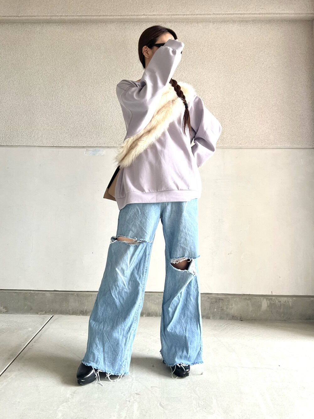 ブラック系のブーツ、ブルー系のデニムパンツ、パープル系のスウェットを着用したレディースの冬コーディネートの5枚目の写真