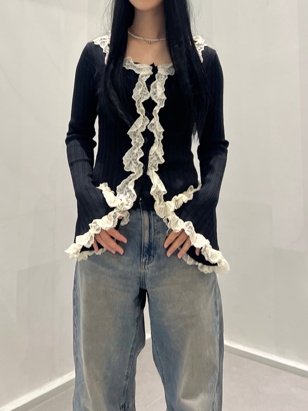 ブラック系のトップス、ブルー系のデニムパンツ、ブラック系のシューズを着用したレディースの秋コーディネートの2枚目の写真