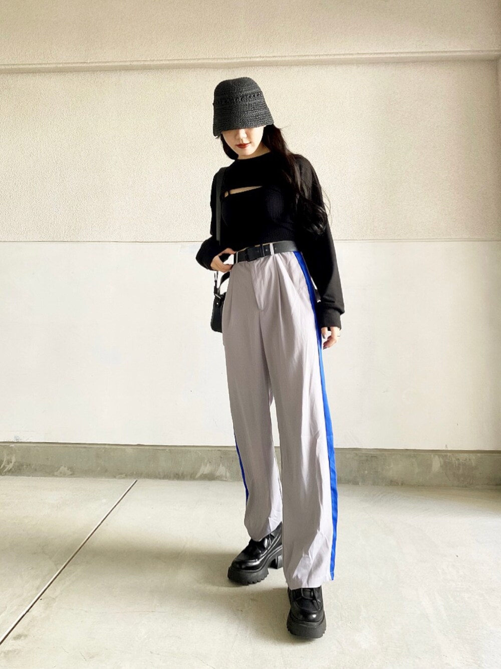 ブラック系のスウェット、グレー系のパンツ、ブラック系のブーツを着用したレディースの春コーディネートの2枚目の写真
