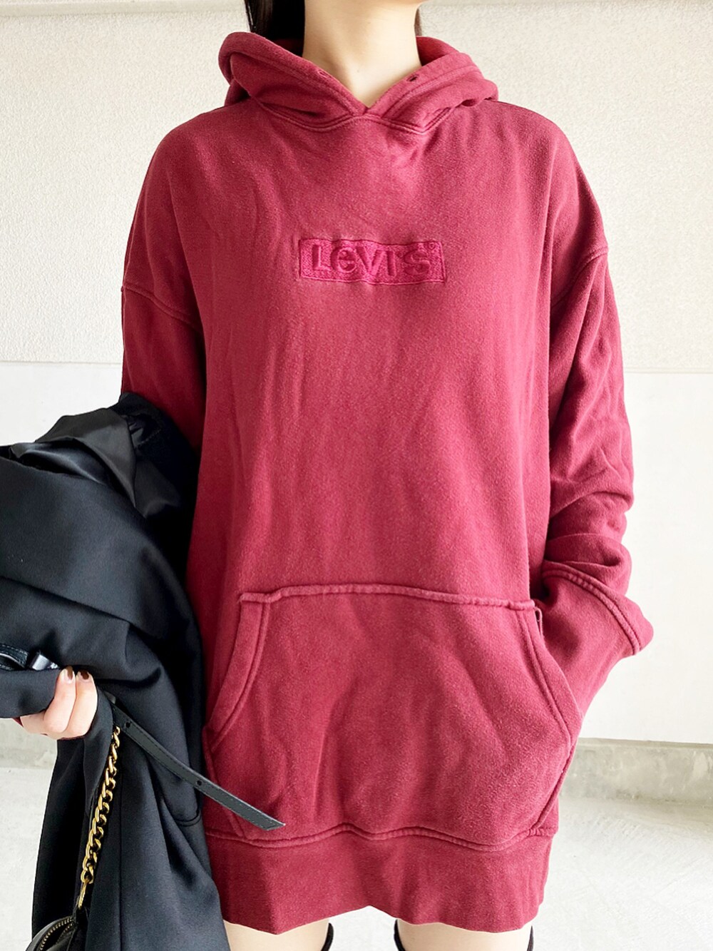 ブルー系のテーラードジャケット、レッド系のパーカー、ブラック系のブーツを着用したレディースの冬コーディネートの3枚目の写真