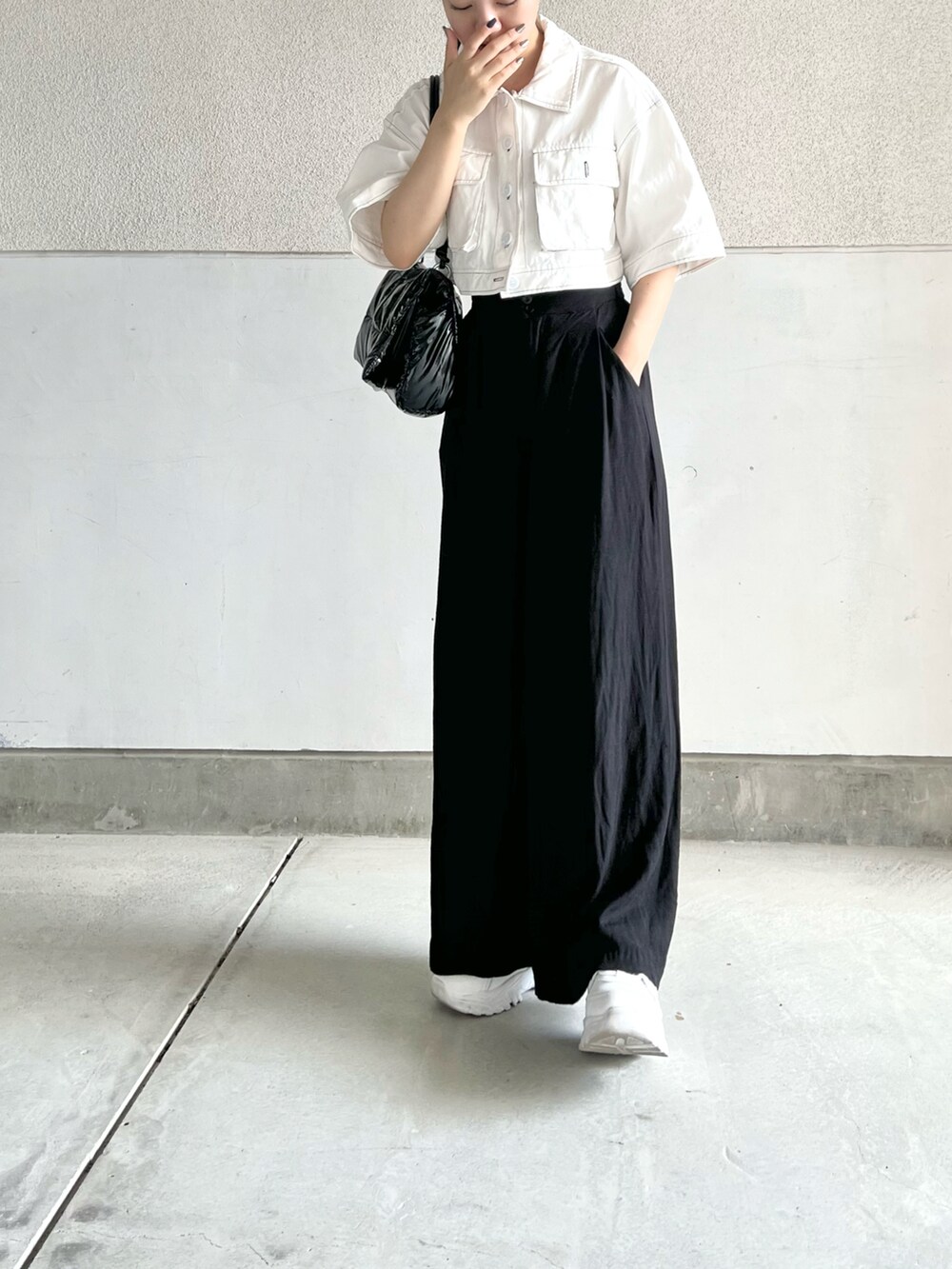 ブラック系のトートバッグ、ブラック系のその他パンツ、ホワイト系のスニーカーを着用したレディースの秋コーディネートの3枚目の写真