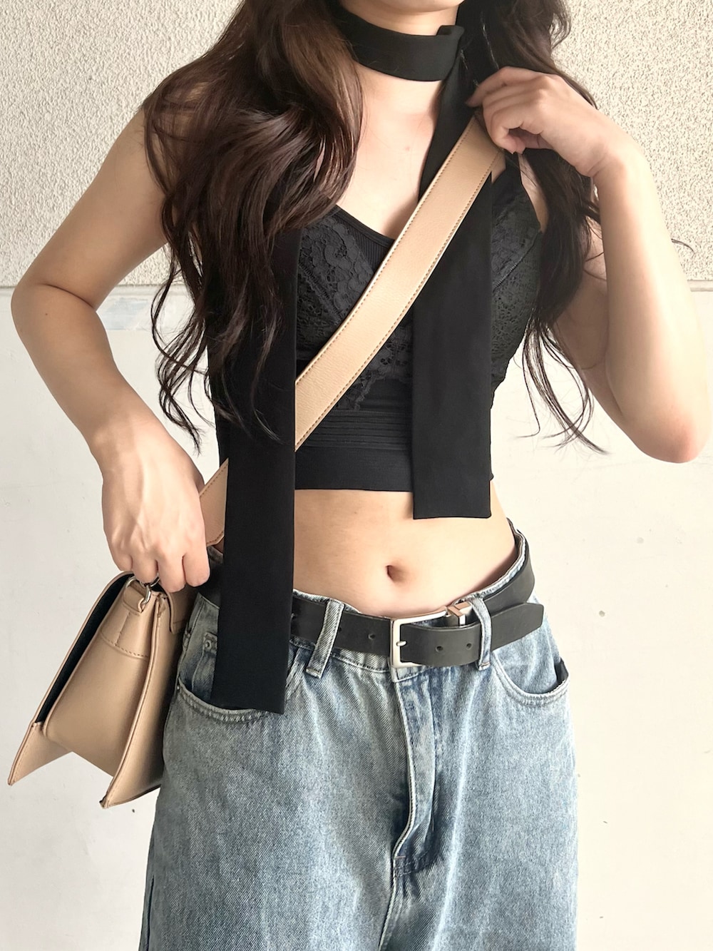 ブルー系のデニムパンツ、ベージュ系のショルダーバッグ、ホワイト系のシューズを着用したレディースの夏コーディネートの5枚目の写真