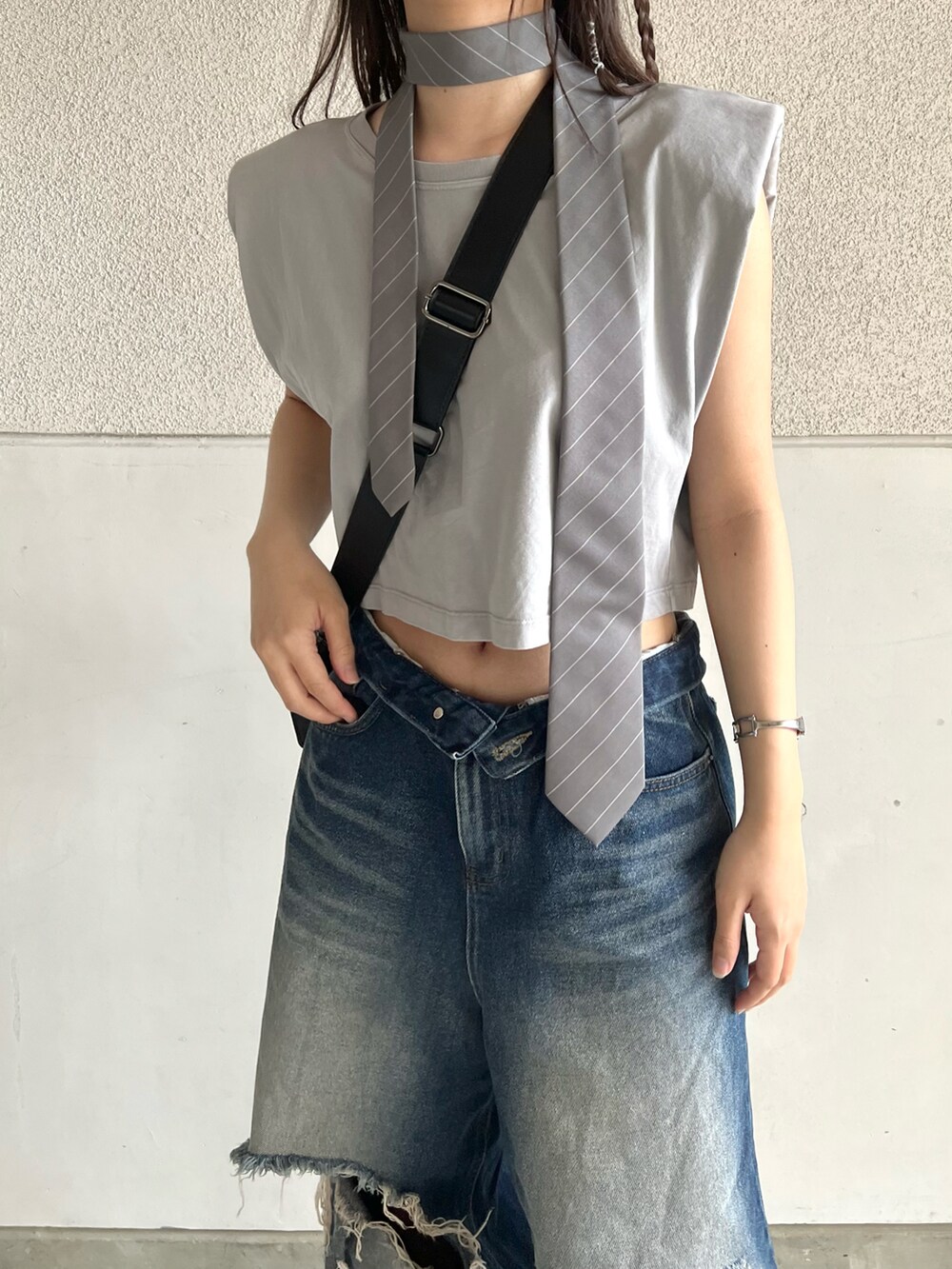 ブラック系のサンダル、グレー系のTシャツ/カットソー、ブルー系のデニムパンツを着用したレディースの夏コーディネートの3枚目の写真