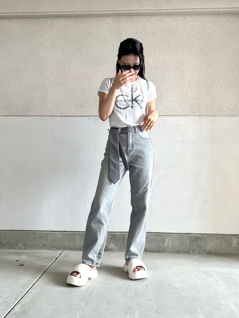 グレー系のパンツ、ホワイト系のTシャツ/カットソー、グレー系のネクタイを着用したレディースの秋コーディネートの5枚目の写真