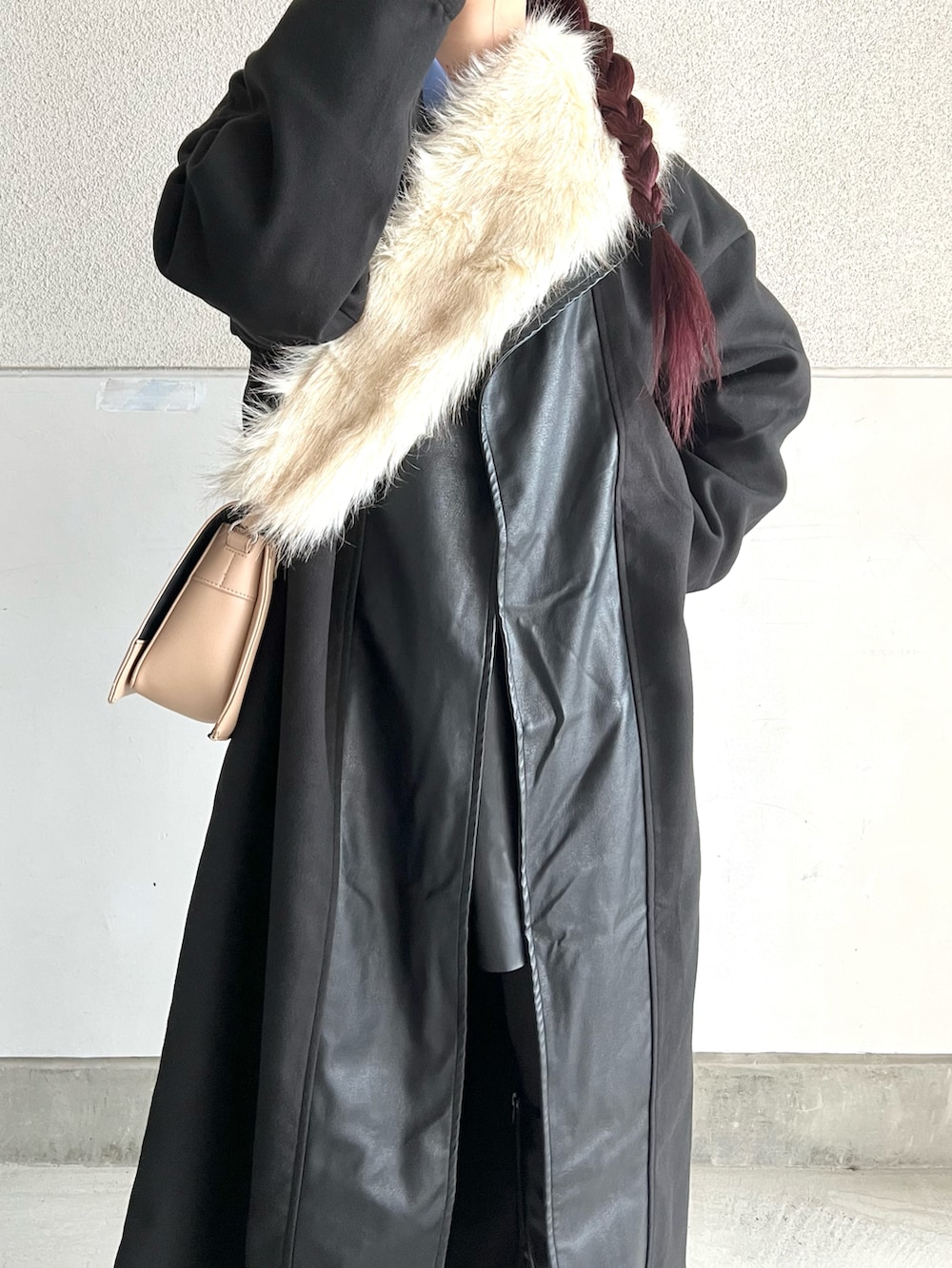 ブラック系のブーツ、ベージュ系のショルダーバッグ、ブラック系のジャケット/アウターを着用したレディースの冬コーディネートの3枚目の写真