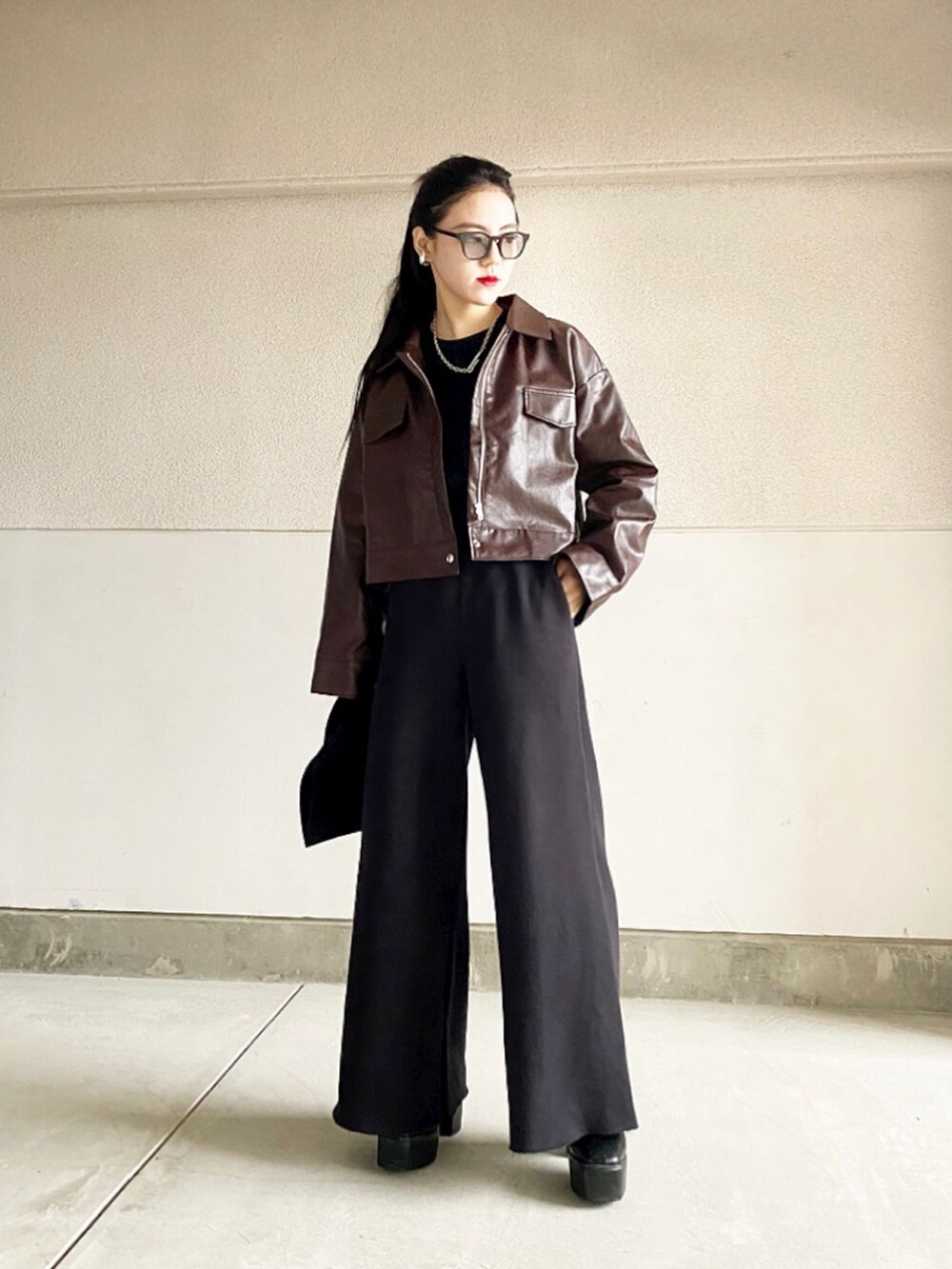 ブラック系のブーツ、ブラック系のパンツ、ブラウン系のジャケット/アウターを着用したレディースの冬コーディネートの2枚目の写真