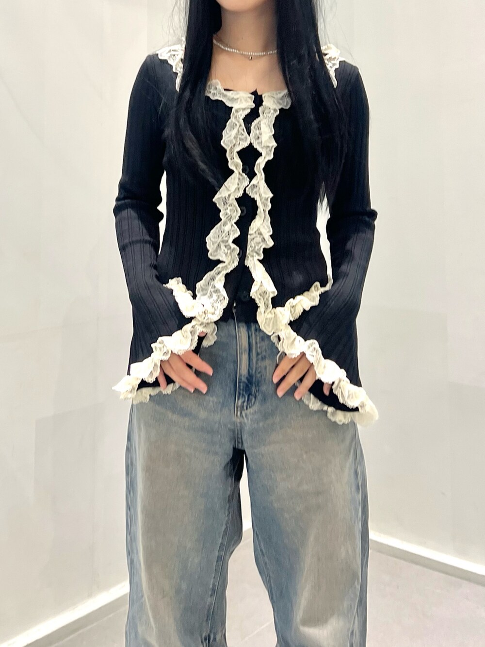 ブラック系のトップス、ブルー系のデニムパンツ、ブラック系のシューズを着用したレディースの秋コーディネートの5枚目の写真