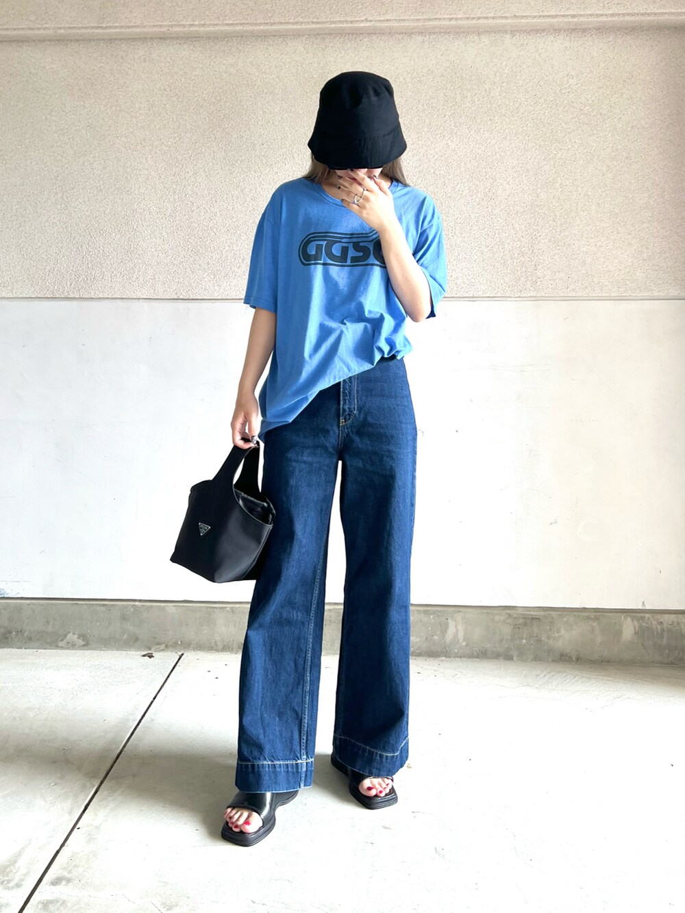 ブルー系のデニムパンツ、ブルー系のTシャツ/カットソー、ブラック系のバッグを着用したレディースの夏コーディネートの3枚目の写真