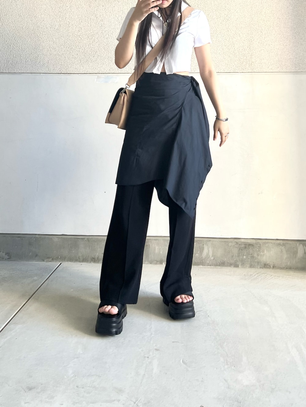 ベージュ系のショルダーバッグ、ブルー系のデニムパンツ、ブラック系のサンダルを着用したレディースの夏コーディネートの3枚目の写真