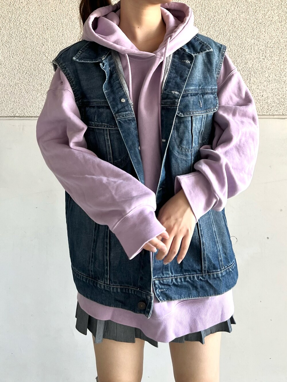 グレー系のスニーカー、ブルー系のデニムジャケット、パープル系のパーカーを着用したレディースの春コーディネートの5枚目の写真