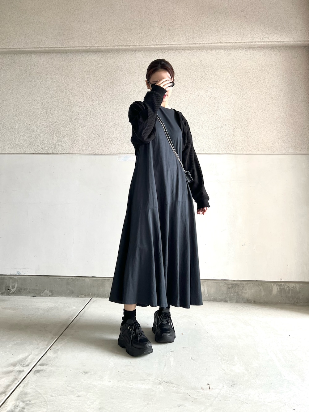 ブルー系のワンピース、ブラック系のスニーカー、ブラック系のトップスを着用したレディースの春コーディネートの4枚目の写真