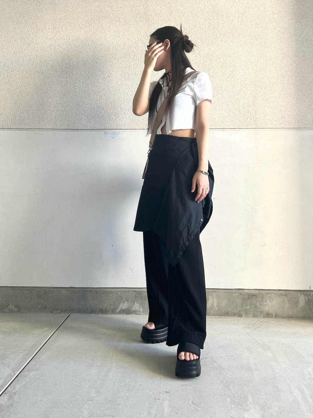 ベージュ系のショルダーバッグ、ブルー系のデニムパンツ、ブラック系のサンダルを着用したレディースの夏コーディネートの4枚目の写真