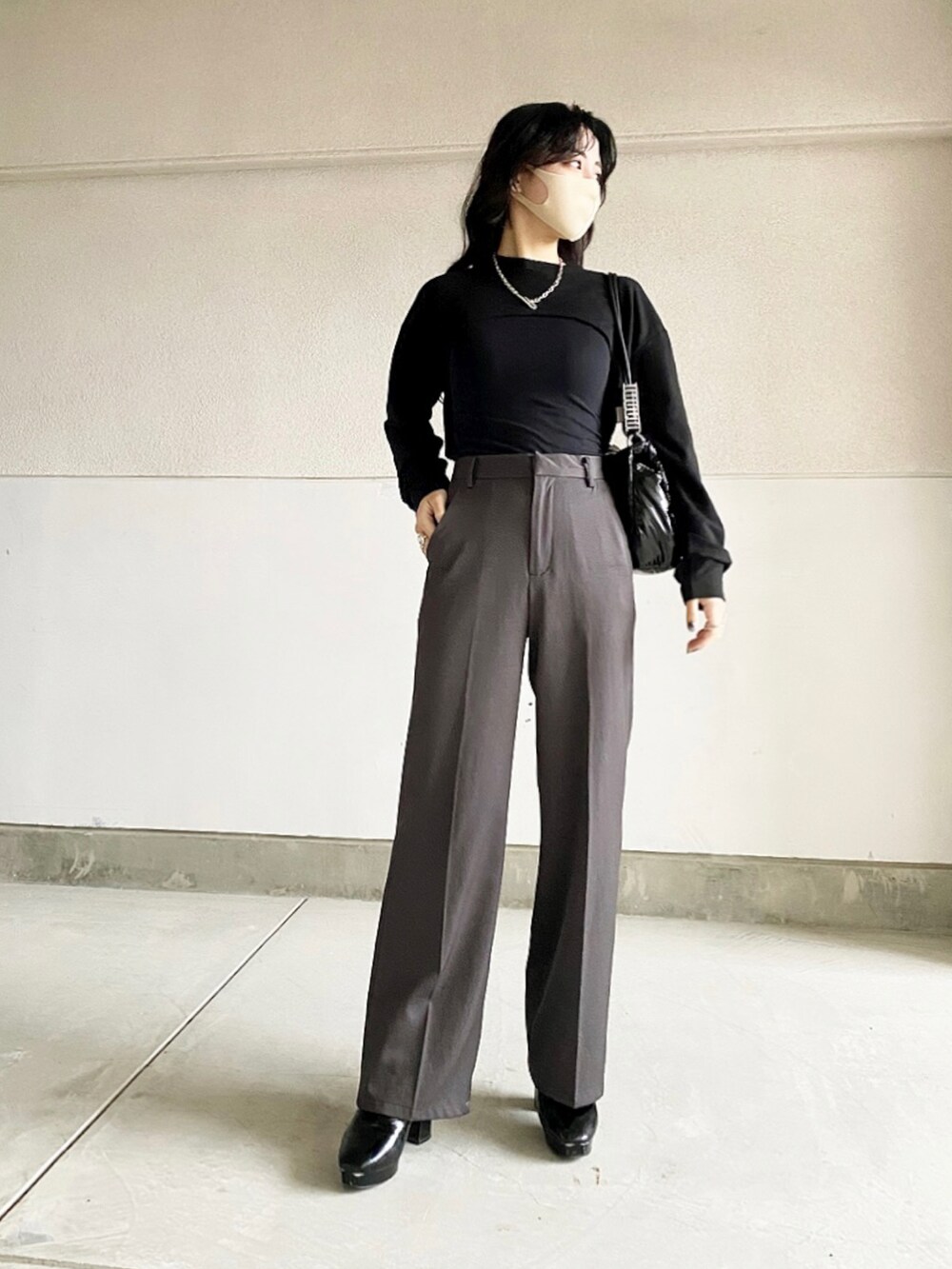 ブラック系のブーツ、グレー系のパンツ、ブラック系のスウェットを着用したレディースの冬コーディネートの2枚目の写真