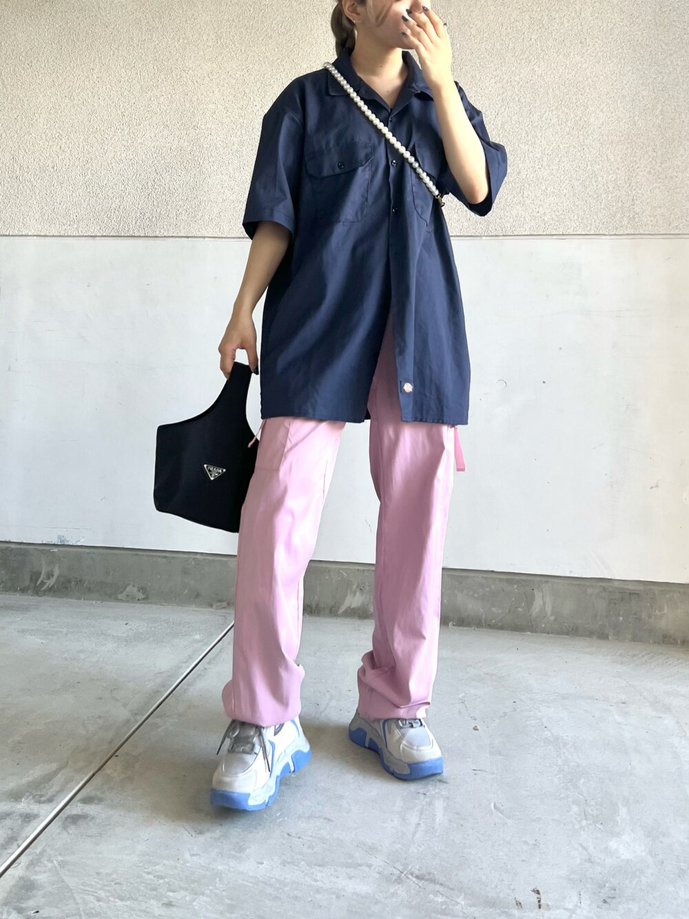 ブルー系のシャツ/ブラウス、ピンク系のパンツ、グレー系のスニーカーを着用したレディースの秋コーディネートの2枚目の写真