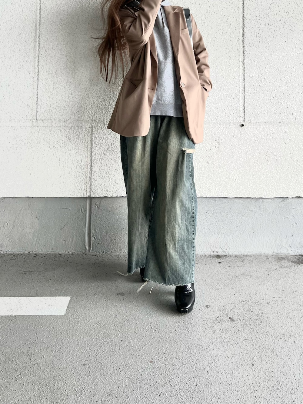 ブラウン系のテーラードジャケット、グレー系のパーカー、ブラック系のブーツを着用したレディースの冬コーディネートの3枚目の写真